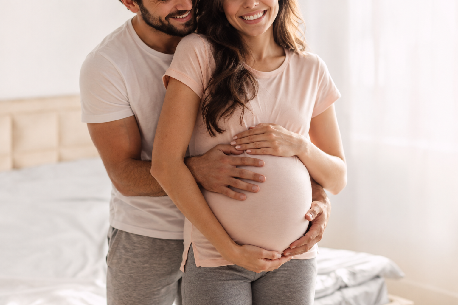 Gravid kvinna tillsammans med stödperson i ljus hemmiljö